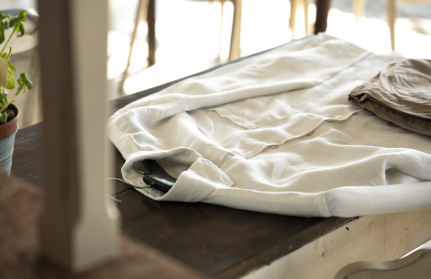 Elegant white shirt folded on wooden table in natural light